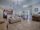 Expansive living room with seamless flow to the dining area, featuring tile floors and neutral color palette at 1408 Deuce Cir, Davenport, FL 33896