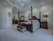 Elegant main bedroom featuring a four-poster bed, tray ceiling, and ample space for furnishings at 1408 Deuce Cir, Davenport, FL 33896