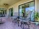 Relaxing covered patio with brick flooring, outdoor seating, and scenic views of the surrounding landscape at 1408 Deuce Cir, Davenport, FL 33896