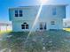 Two-story home with a sunny backyard and sliding glass doors leading to a patio at 1420 Kissimmee Ct, Kissimmee, FL 34759