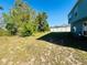 Backyard with mature trees and partial grass, enclosed by a white fence, offers privacy and shade at 1420 Kissimmee Ct, Kissimmee, FL 34759