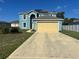 Two-story blue home with a two-car garage, solar panels, and a long driveway at 1420 Kissimmee Ct, Kissimmee, FL 34759
