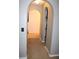 Hallway with arched doorways, carpeting, and tile flooring leads to a closet and a bathroom at 1420 Kissimmee Ct, Kissimmee, FL 34759