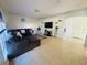 Bright living room featuring tiled flooring, modern furnishings, and neutral decor at 1420 Kissimmee Ct, Kissimmee, FL 34759