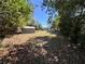 Leafy backyard with a detached storage shed at the edge of the property and the home in the distance at 14346 Sw 39Th Ter, Ocala, FL 34473