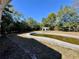 Backyard view with oval in-ground pool, storage shed, and mature trees at 14346 Sw 39Th Ter, Ocala, FL 34473