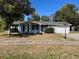 Inviting single-story home with a covered porch, dark shutters and a well-manicured lawn with lamp post at 14346 Sw 39Th Ter, Ocala, FL 34473