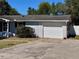 A close up of the garage of a charming home, featuring a white garage door, concrete driveway, and tasteful landscaping at 14346 Sw 39Th Ter, Ocala, FL 34473