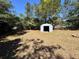 A small, metal storage shed is surrounded by well-kept green grass and mature trees at 14346 Sw 39Th Ter, Ocala, FL 34473