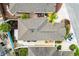 Overhead view of a single-Gathering home featuring a neutral roof, tropical landscaping, and a paved driveway with an parked car at 1536 Barnwell Pl, The Villages, FL 32162