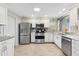 Well-lit kitchen featuring stainless steel appliances, granite countertops, updated cabinets, and modern fixtures at 1536 Barnwell Pl, The Villages, FL 32162