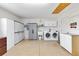 Well-lit laundry room equipped with a washer, dryer, ample cabinet space, and utility sink at 1536 Barnwell Pl, The Villages, FL 32162