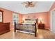 Inviting primary bedroom featuring hardwood floors, a ceiling fan, and ample natural light at 1536 Barnwell Pl, The Villages, FL 32162