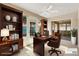 Well-lit home office boasts built-in shelving, desk, and access to the outdoor living space at 1536 Barnwell Pl, The Villages, FL 32162