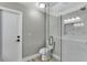 Modern bathroom featuring a toilet with a glass-door walk-in shower and white marble-look wall tiles at 1566 Lawndale Cir, Winter Park, FL 32792