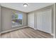Bedroom with a window overlooking the back yard and pool, new flooring and neutral walls at 1566 Lawndale Cir, Winter Park, FL 32792