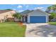 Charming single-story home featuring a blue garage door and well-maintained front lawn at 1566 Lawndale Cir, Winter Park, FL 32792