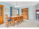 Cozy dining room with wooden furniture, blue accents, and a large window providing natural light and a view of the yard at 161 Williamson Dr, Davenport, FL 33897