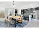 Modern kitchen featuring dark cabinets, stainless steel appliances, a large island, and an adjacent dining area at 161 Williamson Dr, Davenport, FL 33897