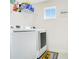 Bright laundry room with modern washer and dryer set, shelf, and a laundry-themed rug at 161 Williamson Dr, Davenport, FL 33897