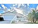 Charming home with a white picket fence, a well-manicured lawn, and a tropical palm tree in the front yard at 1650 Duran Dr, The Villages, FL 32162