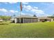 Expansive grassy backyard featuring an enclosed lanai with views of a meticulously maintained lawn at 1733 Oakville Pl, The Villages, FL 32162
