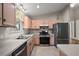 Well-lit kitchen featuring stainless steel appliances and light wood cabinets at 1733 Oakville Pl, The Villages, FL 32162