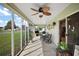 Relaxing enclosed patio with view of grassy lawn, complete with ceiling fan at 1733 Oakville Pl, The Villages, FL 32162