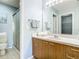 Bathroom with wood vanity and shower with glass door at 17428 Se 82Nd Albemarle Ave, The Villages, FL 32162