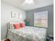 Cozy bedroom featuring a plush patterned bed and a window for natural light at 17428 Se 82Nd Albemarle Ave, The Villages, FL 32162
