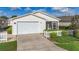 Charming single-story home with a well-manicured lawn, white picket fence, and a two-car garage at 17428 Se 82Nd Albemarle Ave, The Villages, FL 32162