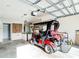 Spacious garage featuring a golf cart, storage shelves, and tool rack for organization at 17428 Se 82Nd Albemarle Ave, The Villages, FL 32162