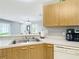 Bright kitchen with laminate countertops and stainless steel sink overlooking the dining area at 17428 Se 82Nd Albemarle Ave, The Villages, FL 32162