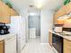 Efficient kitchen featuring white appliances and wood cabinets and access to laundry area at 17428 Se 82Nd Albemarle Ave, The Villages, FL 32162