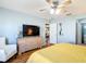 Comfortable main bedroom featuring light walls, wood flooring, and a ceiling fan for added relaxation at 17428 Se 82Nd Albemarle Ave, The Villages, FL 32162