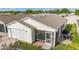 Back of home with a screened-in lanai with seating and a patio with an outdoor dining area at 17428 Se 82Nd Albemarle Ave, The Villages, FL 32162