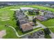 An aerial view showcases the meticulously landscaped neighborhood surrounding the house and the lush green golf course nearby at 17769 Se 121St Terrace Rd, Summerfield, FL 34491