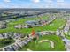 Aerial view shows the property highlighted with a golf course community, a pond and lush landscaping at 17769 Se 121St Terrace Rd, Summerfield, FL 34491