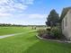 Backyard with a well-maintained lawn, beautiful landscaping, and view of the golf course at 17769 Se 121St Terrace Rd, Summerfield, FL 34491