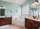 Bright bathroom features double vanities, a soaking tub with tile surround and glass block window at 17769 Se 121St Terrace Rd, Summerfield, FL 34491