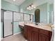 Bathroom features double vanities, marble countertops and glass enclosed shower at 17769 Se 121St Terrace Rd, Summerfield, FL 34491