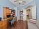Home office featuring hardwood floors, ceiling fan, large desk and shelving at 17769 Se 121St Terrace Rd, Summerfield, FL 34491