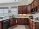 Well-equipped kitchen featuring granite countertops, cherry wood cabinets, and stainless steel appliances at 17769 Se 121St Terrace Rd, Summerfield, FL 34491