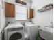 Bright laundry room with white appliances, upper wood cabinets, sink and a 'Laundry Room' sign for added charm at 17769 Se 121St Terrace Rd, Summerfield, FL 34491
