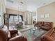 Open concept living room and dining area with brown leather furniture and natural light at 17769 Se 121St Terrace Rd, Summerfield, FL 34491