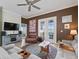 Inviting living room with a TV, brown leather furniture, and french door access to the outdoors at 17769 Se 121St Terrace Rd, Summerfield, FL 34491