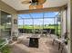 Screened patio featuring stone floors, outdoor seating with a fire pit, and beautiful golf course views at 17769 Se 121St Terrace Rd, Summerfield, FL 34491