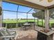 Spacious screened patio with a dining table, fire pit, comfortable seating, and golf course view at 17769 Se 121St Terrace Rd, Summerfield, FL 34491