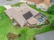 Aerial view of the home with screened pool, solar panels, and landscaped yard at 1804 Estafana Way, The Villages, FL 32159