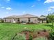 Well-maintained backyard with lush lawn, mature landscaping, and screened enclosure at 1804 Estafana Way, The Villages, FL 32159